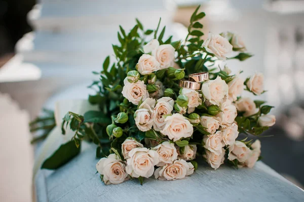 Guld vigselringar på rosa bukett blommor — Stockfoto