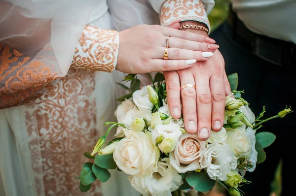 Bruid en bruidegom handen met bloem boeket — Stockfoto