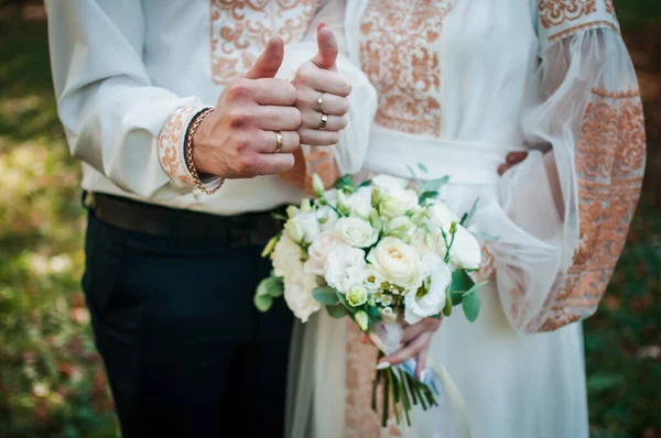 Noiva e noivo mãos com buquê de flores — Fotografia de Stock