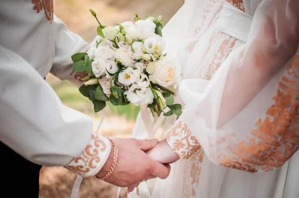 Νύφη και γαμπρός χέρια με λουλούδι μπουκέτο — Φωτογραφία Αρχείου