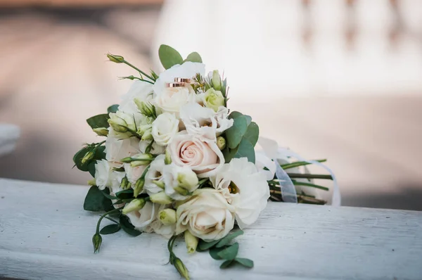 Par de anéis de casamento de ouro no buquê de flores brancas — Fotografia de Stock