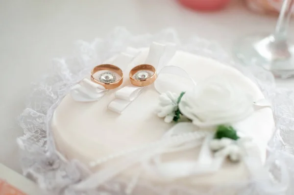 Par de anillos de boda dorados en la almohada blanca —  Fotos de Stock