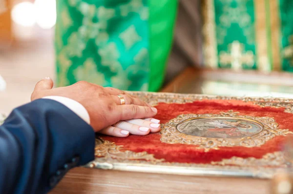 Groom and bride holding hands on the bible — Stock Photo, Image