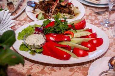 Sebzeleri beyaz tabakta dilimliyorum.