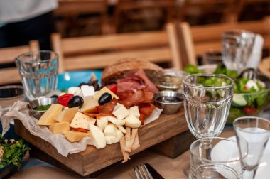 Farklı peynir ve et çeşitleri dilimleniyor.