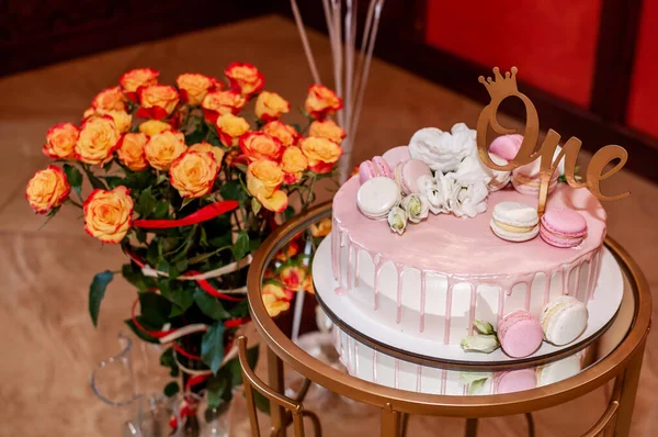 スタンドにはお祝いのケーキとオレンジのバラの花束。 — ストック写真