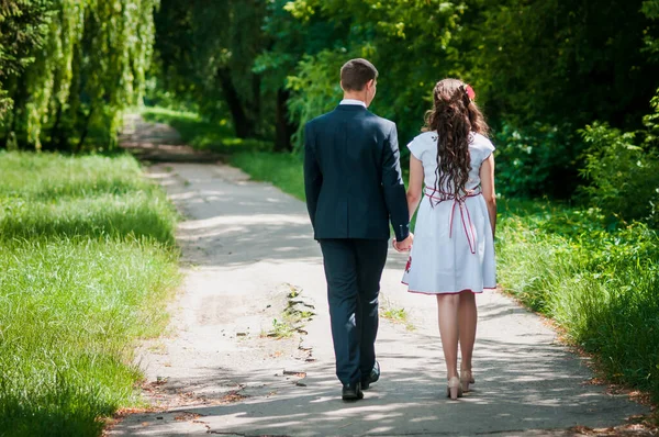 De man met het meisje loopt in het zomerpark. — Stockfoto