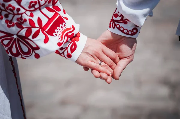 新婚夫妇手牵手 穿着红色绣花衣服 — 图库照片