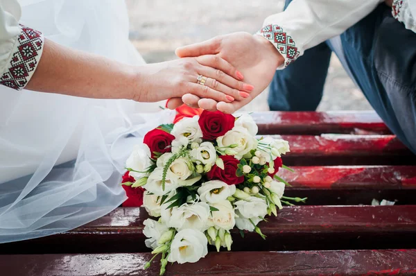 新婚夫婦は結婚式の花束を背景に手を取り合って — ストック写真