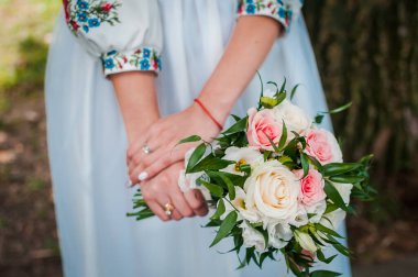 Beyaz ve pembe güllerin gelininin ellerinde düğün buketi