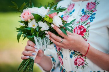 Beyaz ve pembe güllerin gelininin ellerinde düğün buketi