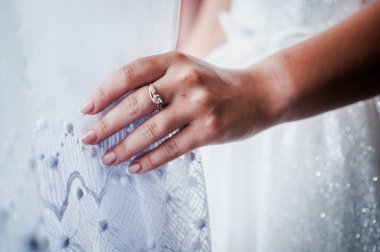 Gelin elinde altın bir yüzük tutuyor.