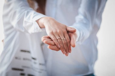 Nikah yüzüklü yeni evlilerin elleri.