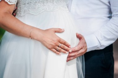 Kadın ve erkeğin elleri hamile karnında