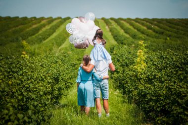 Aile üzümlü bahçede yürüyor.