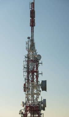 Mavi gökyüzüne karşı antenli iletişim kulesi