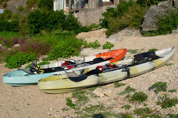 Skadar Gölü kıyısındaki kayalık bir yüzeyde farklı renklerde birçok plastik kano bulunur..