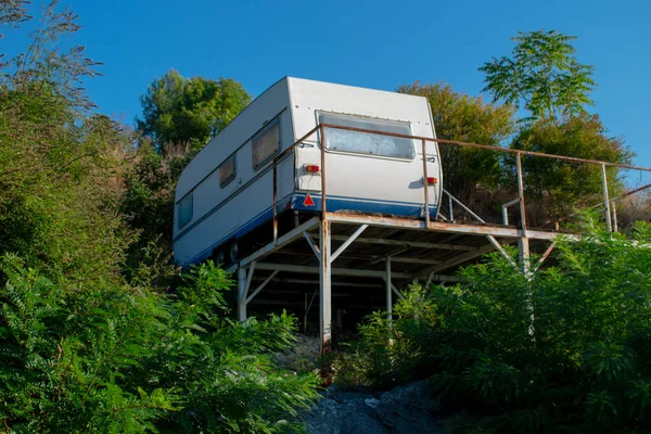 Bir görüntü, Skadar Gölü kıyısındaki bir platformda duran tekerlekli bir karavanı gösteriyor..