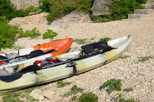 Skadar Gölü kıyısındaki kayalık bir yüzeyde farklı renklerde birçok plastik kano bulunur..