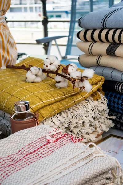 Görüntü, bir el sanatları festivalinde sergilenen Türk peshtemal havlusunu gösteriyor. Geleneksel tekstil işçiliği, parlak renkleri ve piyasa tarzı atmosferi olan bir aile şirketini vurguluyor.