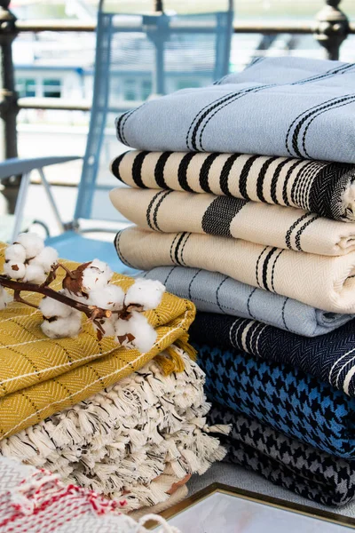 Görüntü, bir el sanatları festivalinde sergilenen Türk peshtemal havlusunu gösteriyor. Geleneksel tekstil işçiliği, parlak renkleri ve piyasa tarzı atmosferi olan bir aile şirketini vurguluyor.