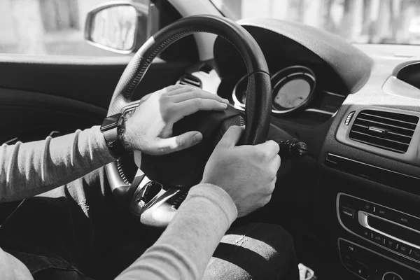 Primer plano de un hombre con las manos sosteniendo el volante mientras conduce el coche — Foto de Stock