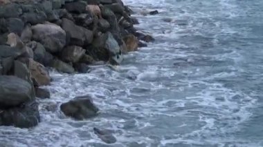 Dalgalar deniz hakkında taşlar. Gelgit geçişli.