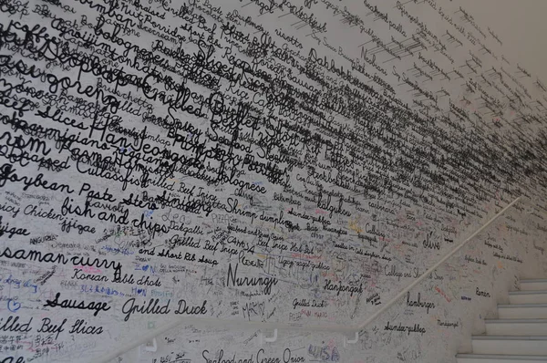 Beyaz duvar siyah yazıtları ve merdiven.