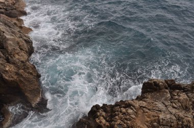 Kayalık sahil ve dalgalar. Gelgit geçişli. Öğe.