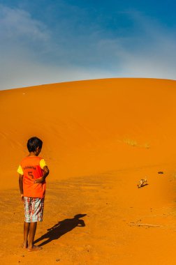 Çocuk Fas Merzouga çölde bir tilki çöl (çöl tilkisi) yakalamaya çalışıyor