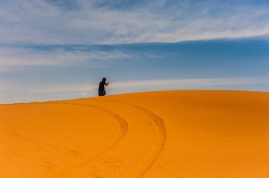 Yalnız bir kumul Merzouga, Fas üzerinde yürüyen eski berber kadın