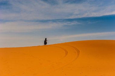 Yalnız bir kumul Merzouga, Fas üzerinde yürüyen eski berber kadın