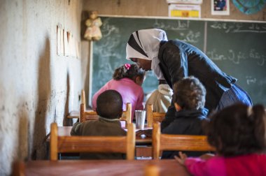 Okulun içinde öğrenciler ve öğretmen Khamila Köyü, Fas