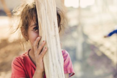 Kız bir ahşap direğin arkasına gizler