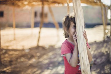 Kız bir ahşap direğin arkasına gizler