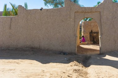 Merzouga, Fas onun evinin önünde oturan kız