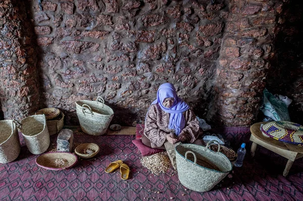 Argan yağı üretim. Argan somun bir taşla sert kabuklu çatlama Berberi bir kadın. Essaouira, Morocco