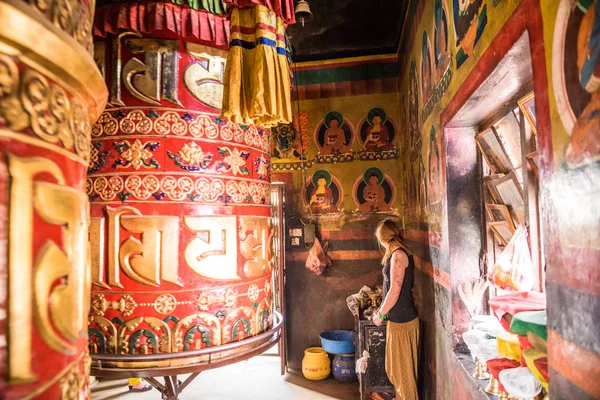 一名妇女站在亚洲加德满都的 Boudhanath Stupa 神庙的一个大型祈祷轮旁 — 图库照片