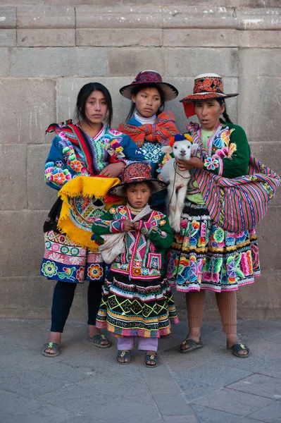 Perulu geleneksel elbiseli ve lamalı aile Cusco, Peru 'da fotoğraf için poz veriyor.