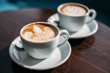 iki fincan cappuccino latte art ahşap masa Tarih ile