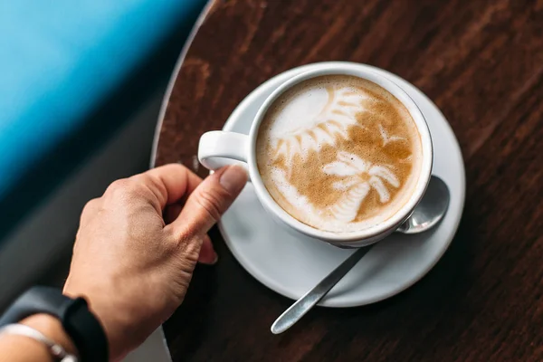 Tahta masada bir fincan sıcak latte sanat kahvesi.