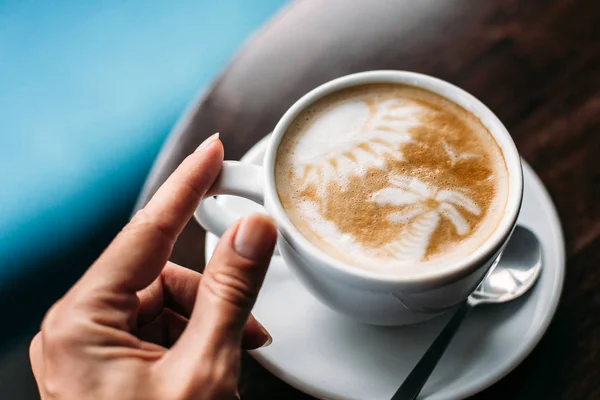 Tahta masada bir fincan sıcak latte sanat kahvesi.