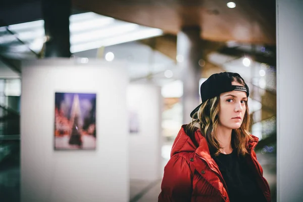 Dalgın yüz resimleri, Sanat Galerisi ile duvarın yanında poz ile ayakta şık şapkası kırmızı ceketli trendy sevimli kız