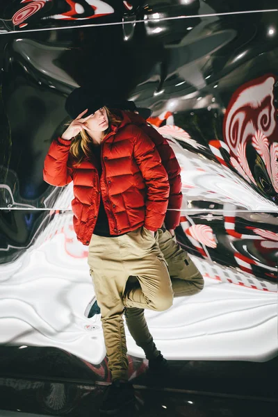 Sahte cam üzerine eğilerek şık şapkası kırmızı ceketli trendy sevimli kız