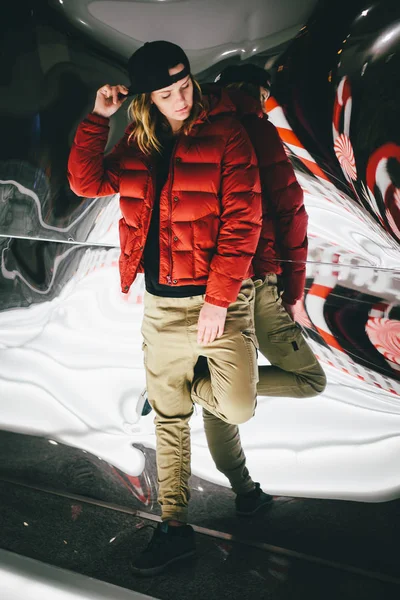 Sahte cam üzerine eğilerek şık şapkası kırmızı ceketli trendy sevimli kız