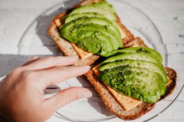 Avokado, peynir ve otlar ile tam buğday tost. Yararlı bir lezzetli breakfast.