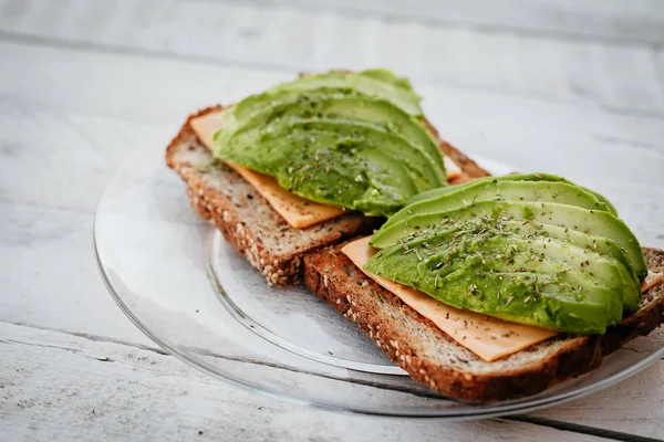 Otlar, peynir ve ekmek ahşap arka plan üzerinde avokado sandviç