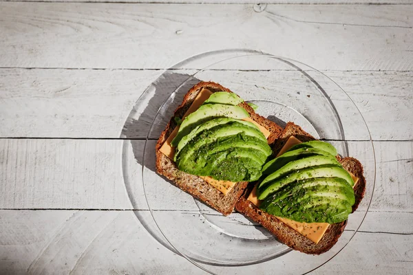 Otlar, peynir ve ekmek ahşap beyaz arka plan üzerinde avokado sandviç