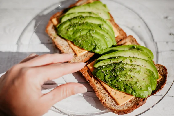 Avokado, peynir ve otlar ile tam buğday tost. Yararlı bir lezzetli breakfast.