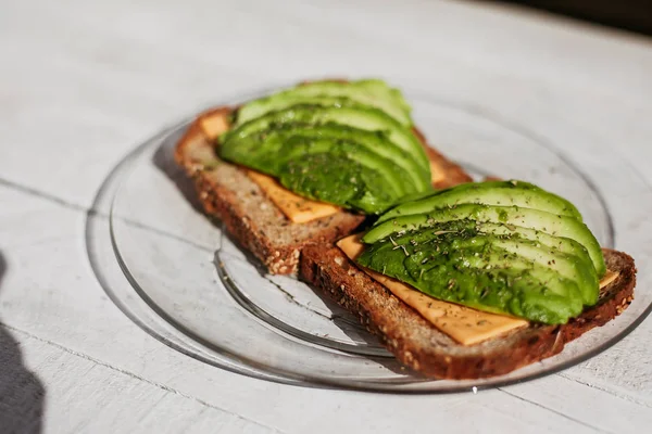 Otlar, peynir ve ekmek ahşap beyaz arka plan üzerinde avokado sandviç. Yumuşak odak